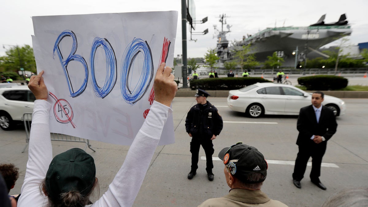  A protestor holds up a sign during a rally across the street from the Intrepid Sea, Air & Space Museum, where President Donald Trump arrived for the 75th Anniversary Battle of the Coral Sea Commemorative Dinner on the USS intrepid, Thursday, May 4, 2017, in New York. (Julio Cortez/AP Photo) 