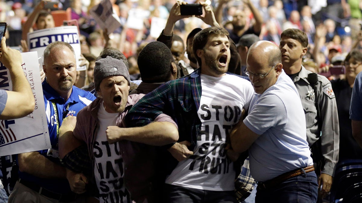 Protesters are removed as Republican presidential candidate Donald Trump speaks during a campaign rally in Fayetteville