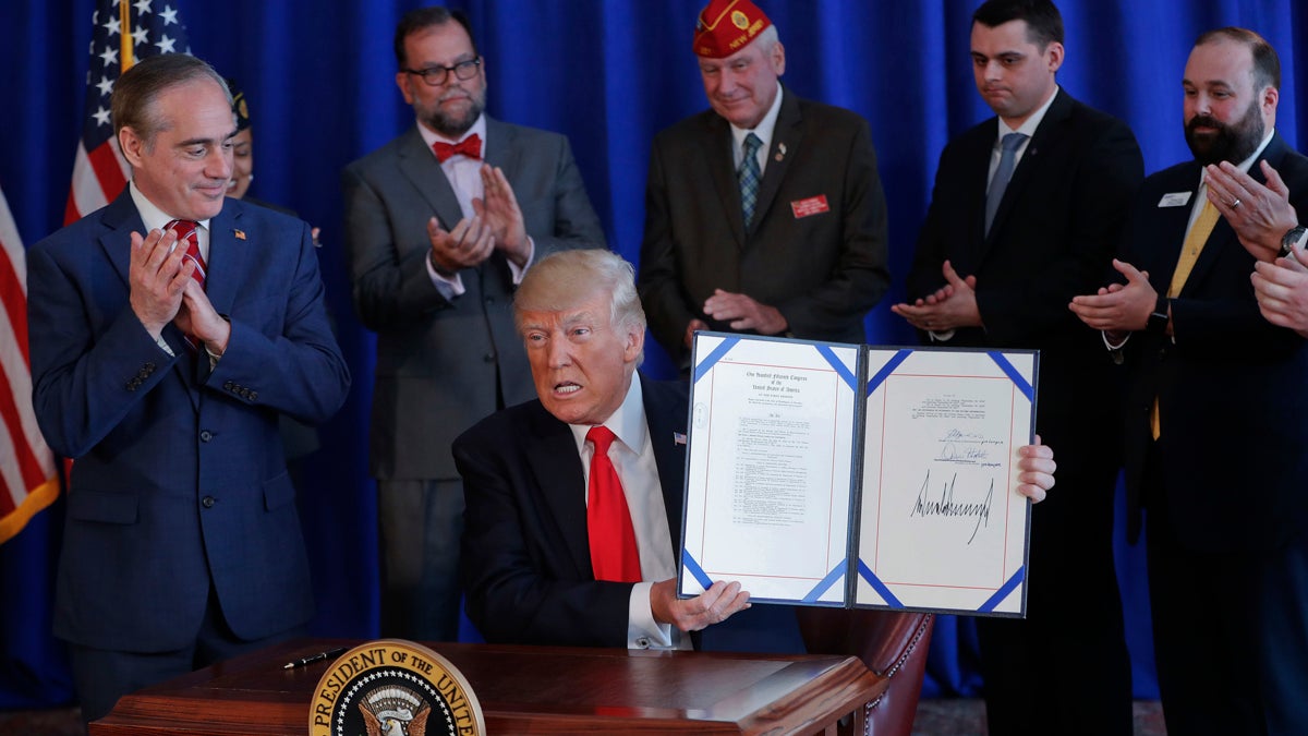  President Donald Trump holds the Veteran's Affairs Choice and Quality Employment Act of 2017 after signing it at Trump National Golf Club in Bedminister, N.J., Saturday, Aug. 12, 2017. Standing with Trump is Veterans Affairs Secretary David Shulkin, left. (Pablo Martinez Monsivais/AP Photo) 
