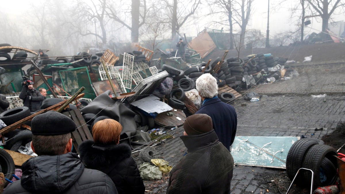 Secretary of State John Kerry looks at a barricade at the Shrine of the Fallen in Kiev