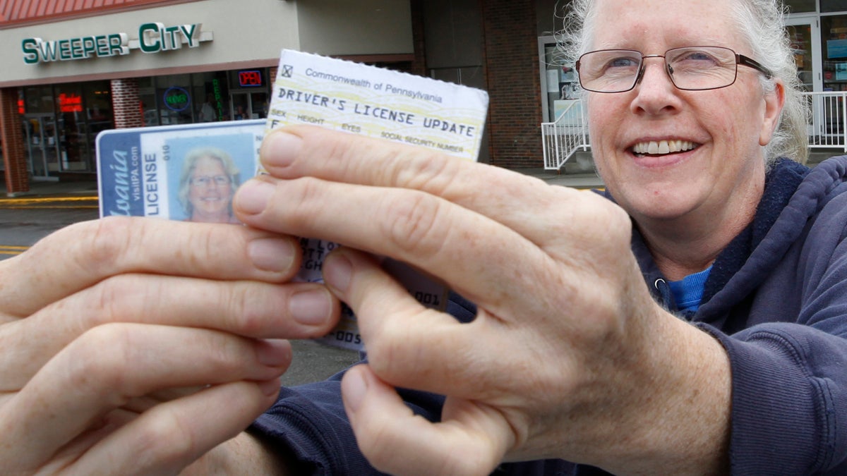 Kathryn Whitecotton covers her personal information as she shows her Pennsylvania drivers license and her address update card outside the Penndot Drivers License Center. (Keith Srakocic/AP Photo) 