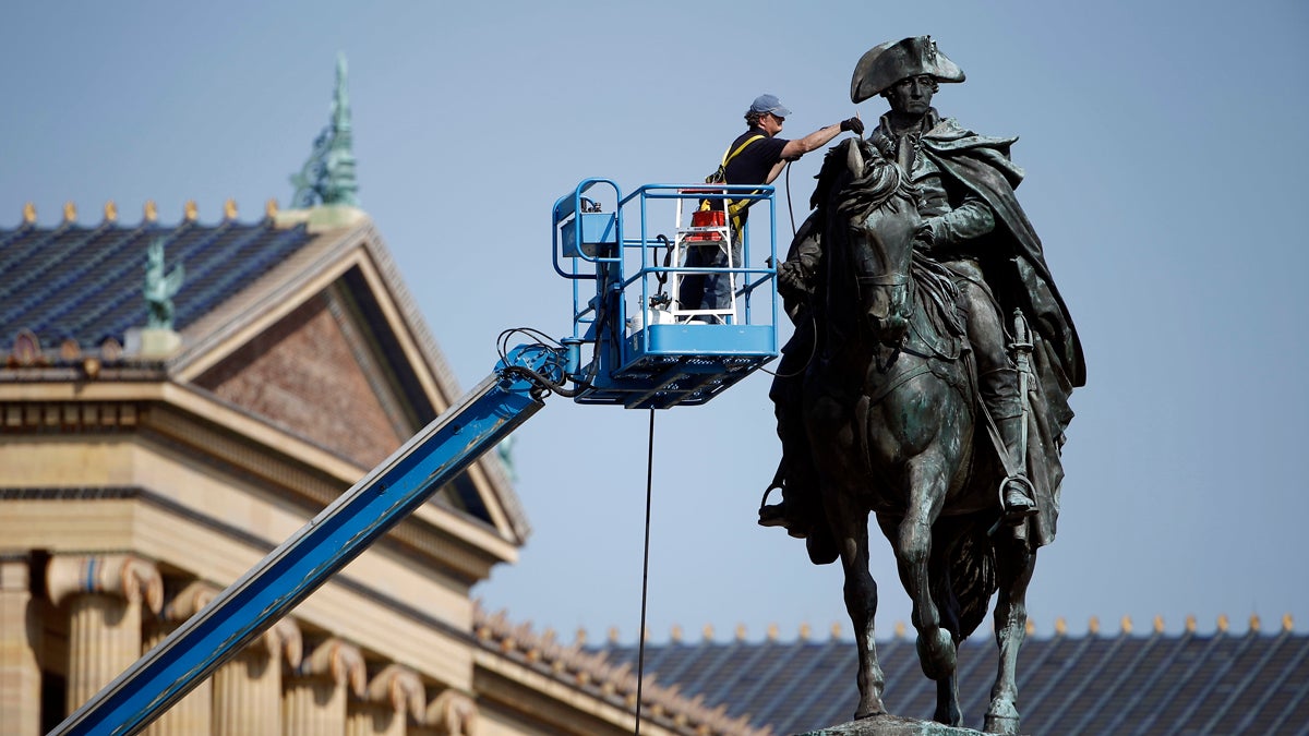 Art conservator Douglas Martenson applies a patina to a bronze statue of George Washington that stands near the Philadelphia Museum of Art. In honor of Labor Day