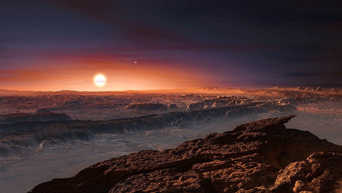 This artist’s impression shows a view of the surface of the planet Proxima b orbiting the red dwarf star Proxima Centauri, the closest star to the Solar System. The double star Alpha Centauri AB also appears in the image to the upper-right of Proxima itself. Proxima b is a little more massive than the Earth and orbits in the habitable zone around Proxima Centauri, where the temperature is suitable for liquid water to exist on its surface. (<a href=