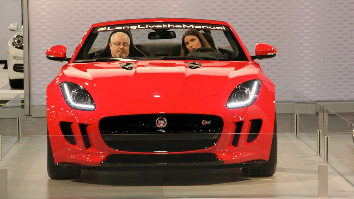 Visitors at the Philadelphia Auto Show preview try out a Jaguar. (Emma Lee/WHYY)