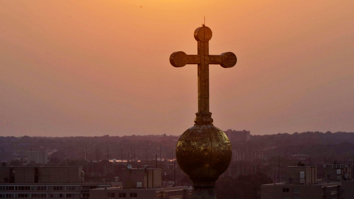  The sun sets behind the cross atop the dome of the Basilica of St. Peter and St. Paul. (AP Photo/Alex Brandon) 
