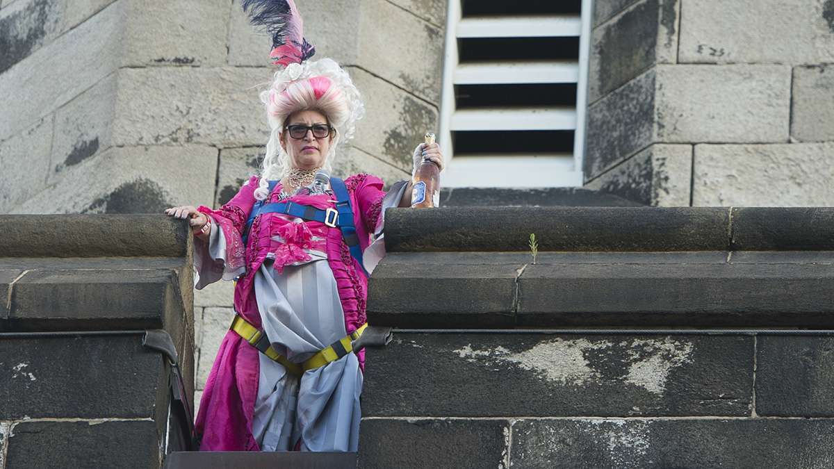 Marie Antoinette, played by Terry McNally, scowls from the top of the penitentiary walls.