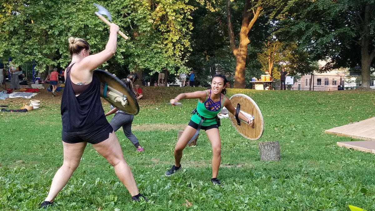  Brandi Burgess (left), playing a Volscian lieutenant, and Alexandra Palting, playing a Roman soldier, rehearse their battle scene for Shakespeare in Clark Park's production of Coriolanus. (Peter Crimmins/WHYY) 
