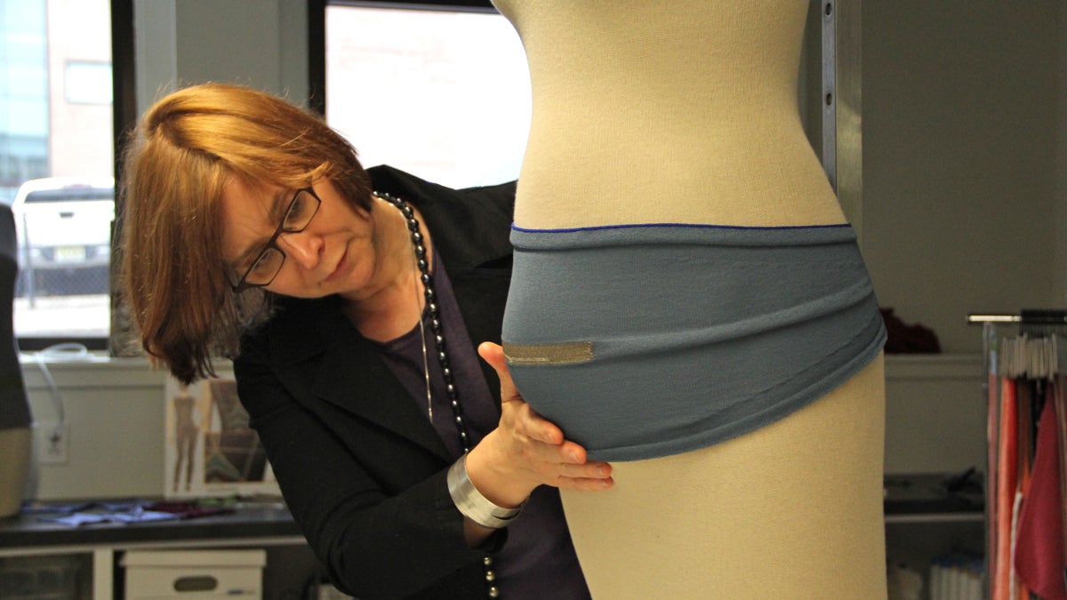  Drexel University's Genevieve Dion arranges a belly band on a model at the Shima Seiki Haute Technology Lab. (Emma Lee/WHYY) 