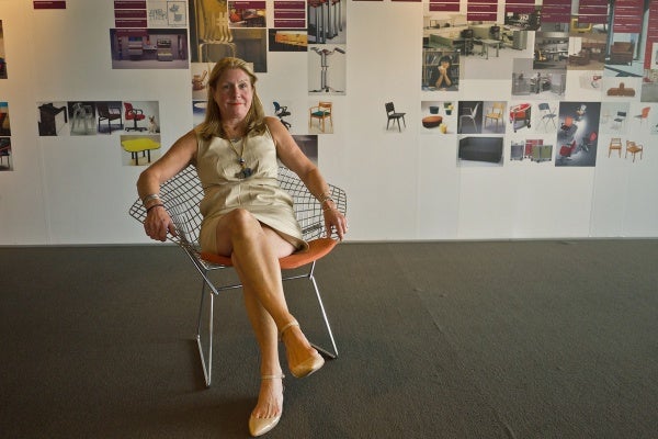Carol Connell, account manager for Knoll, sits in the Bertoia Diamond Chair. (Charile Kaier/WHYY)