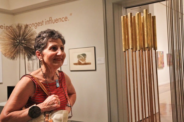 Roberta Hurley of Lambertville, N.J., fan of sculptor Harry Bertoia, appreciates the sound of one of his tonal sculptures on display at the Michener Museum. (Kimberly Paynter/WHYY)