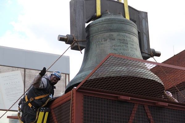 <p>Ironworker  Kevin Dukes guides the Bicentennial Bell into a crate where it will be stored until a new home is constructed for it. (Emma Lee/for NewsWorks)</p>
