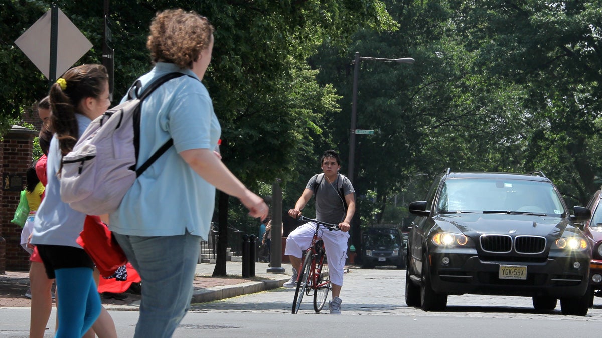  Look at everyone behaving so nicely: Bicyclist stopped at a red light, motorist peacefully coexisting, pedestrians crossing in the crosswalk. (Emma Lee/for NewsWorks) 