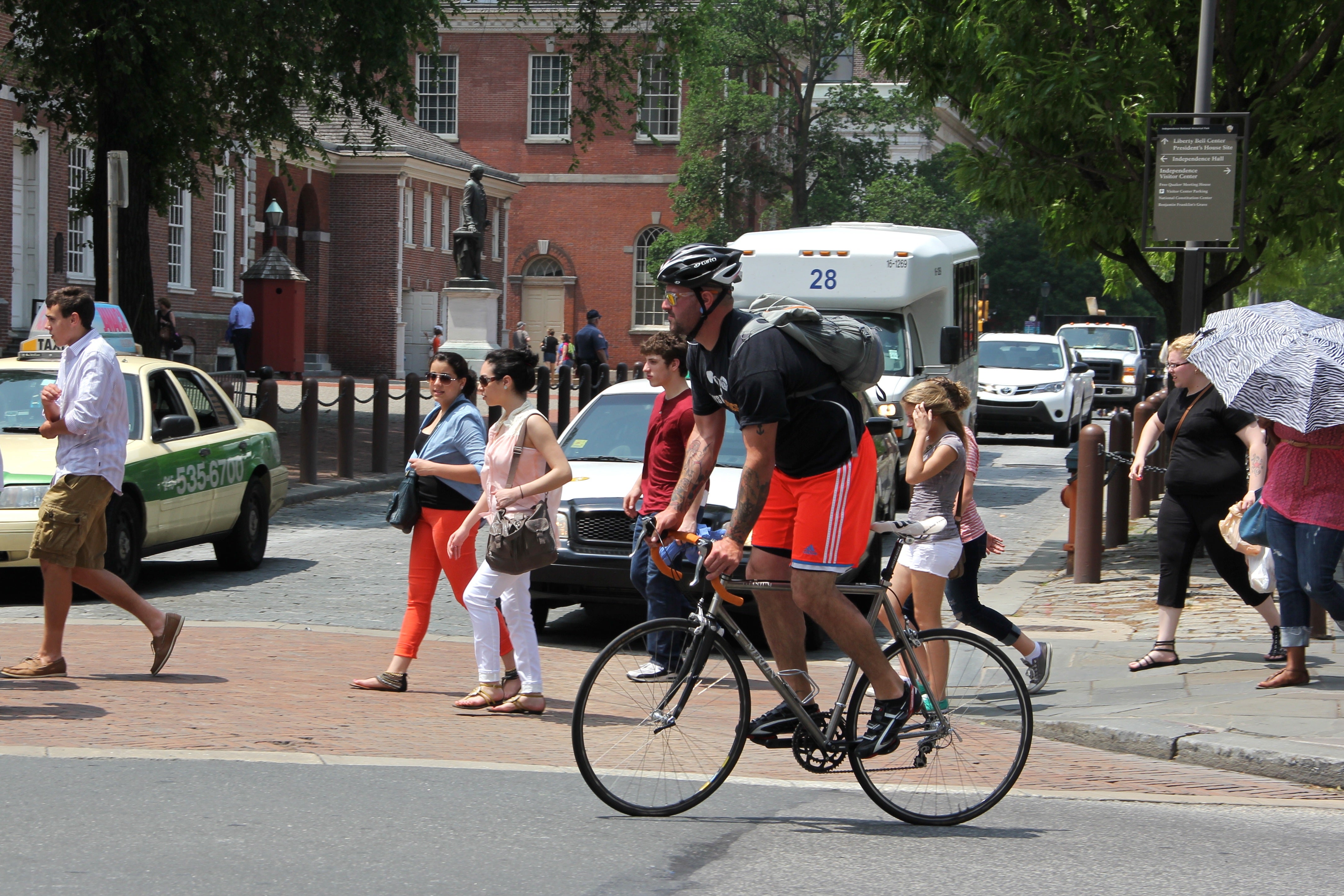  Cyclists and pedestrians cross the street in Philadelphia. (Emma Lee/Newsworks) 