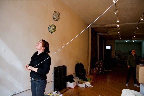 <p><p>Architect and designer Cary Clouse hangs a wire as part of the Toss exhibit at the Storefront for Urban Innovation in Philadelphia. (Lindsay Lazarski/WHYY)</p></p>
