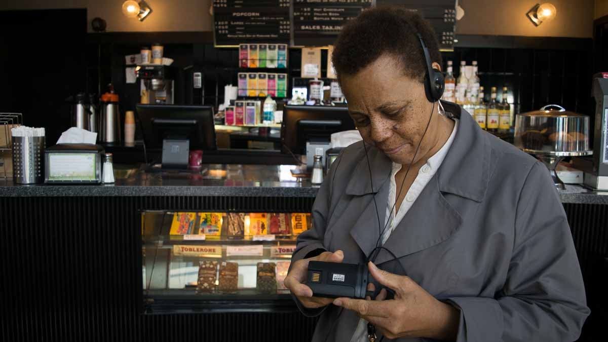 Sarita Kimble holds an audio description device at the Ritz Five movie theater in Philadelphia. (Paige Pfleger/WHYY)