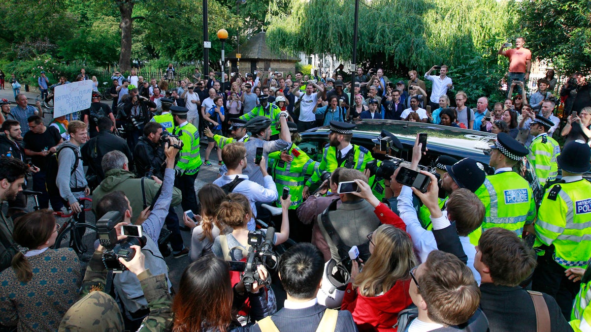 People gather around the car of British MP Boris Johnson
