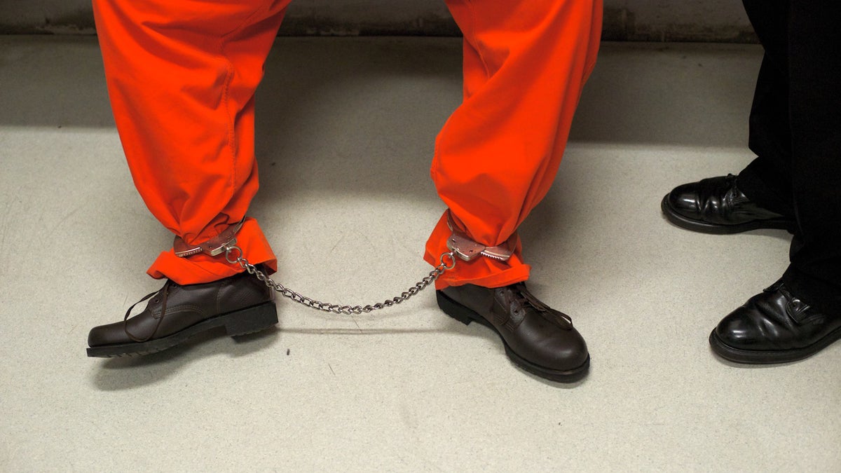  An inmate wearing a orange jumpsuit is seen chained up in the transition area that leads to the maximum security facility of the prison. (Bas Slabbers/for NewsWorks) 
