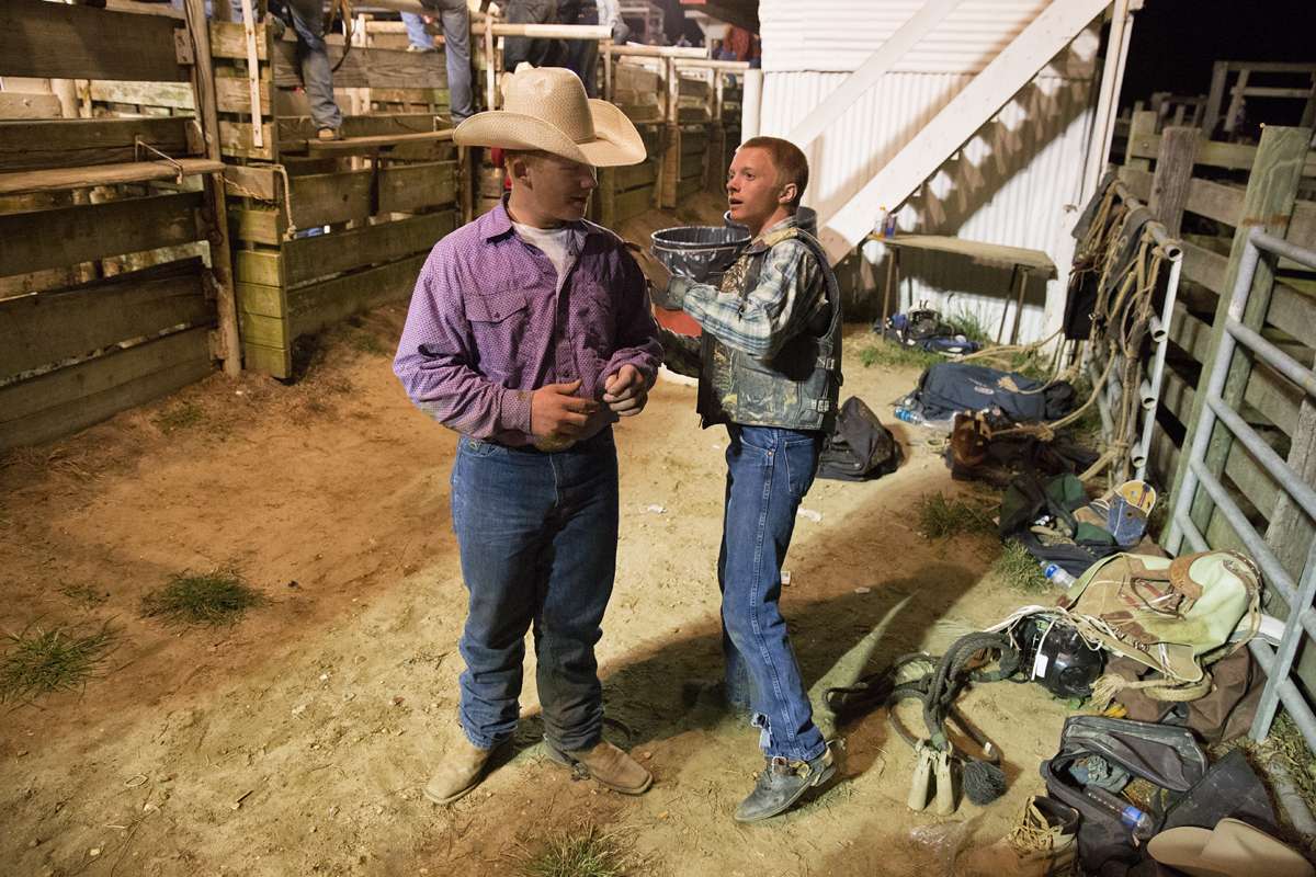 Clay Harp and Parker Ship show each other fresh bumps and scraps from the junior bull riding competition. (Lindsay Lazarski/WHYY)