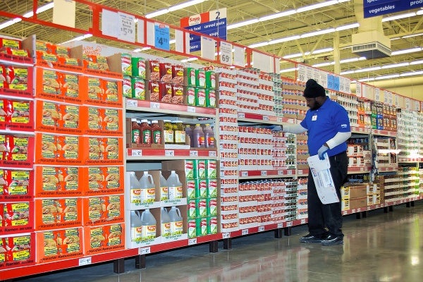 A Save-A-Lot employee places canned goods in Aisle 3. (Bas Slabbers/for NewsWorks)
