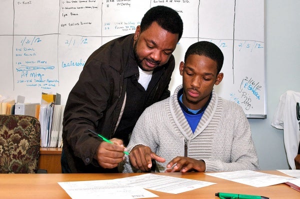 Vincent Booker signs along with his son Myles. (Bas Slabbers/for NewsWorks)