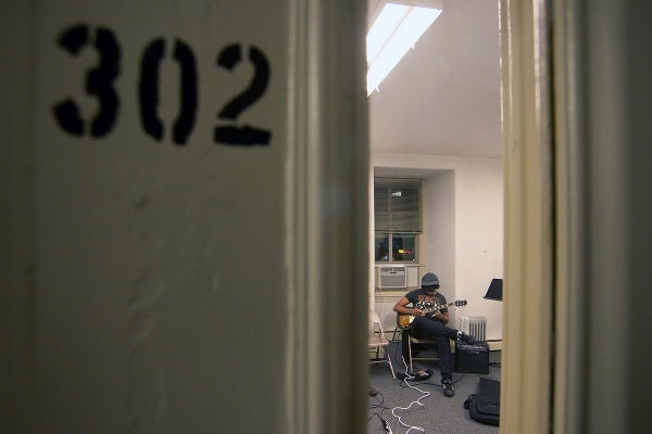 <p>Guitarist Darren Davis sits in room 302 of the Germantown Settlement Music School. (Bas Slabbers/for NewsWorks)</p>

