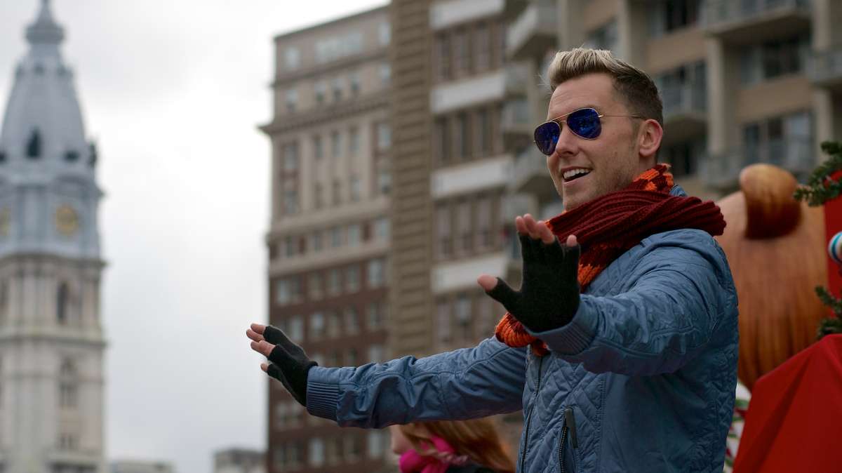Former N’Sync member Lance Bass waves as he stands on the float that rides him down the Parkway. (Bas Slabbers/for NewsWorks)