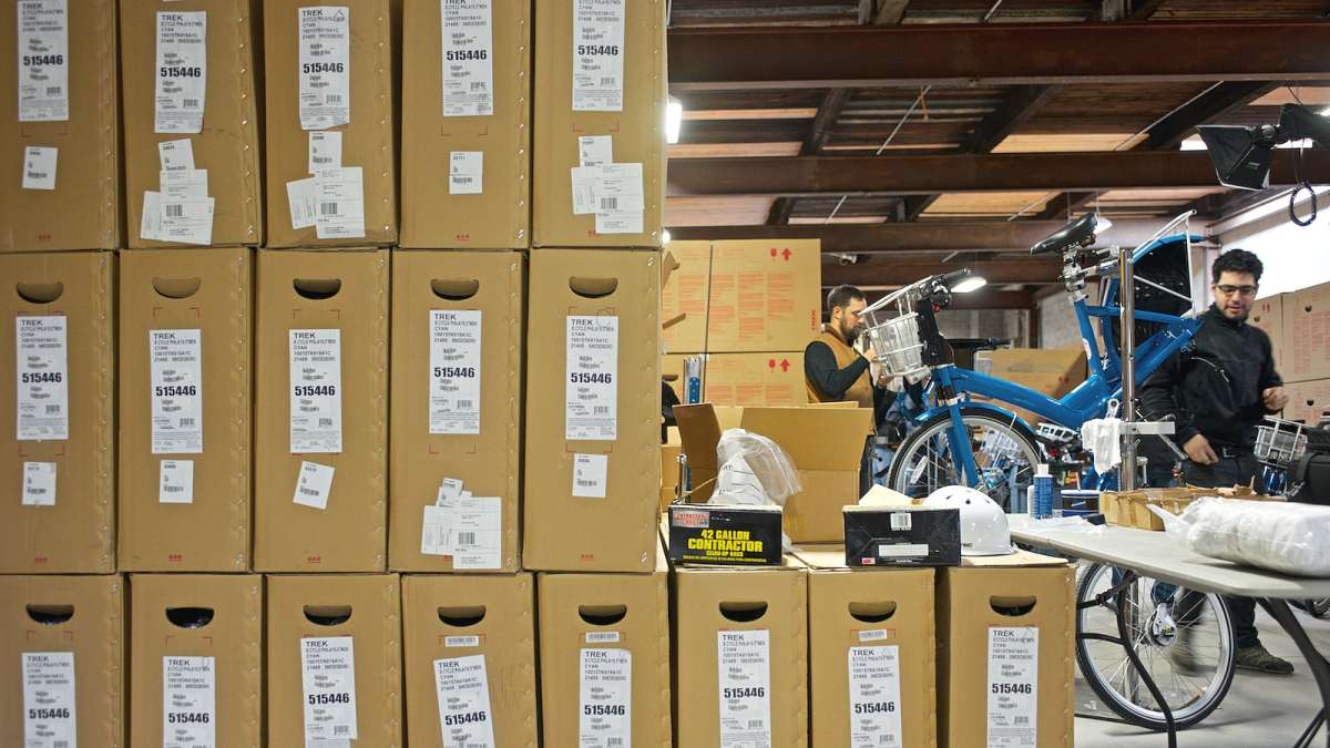 Hundreds of bikes in boxes wait to be assembled by a team of mechanics. (Bas Slabbers/for NewsWorks)