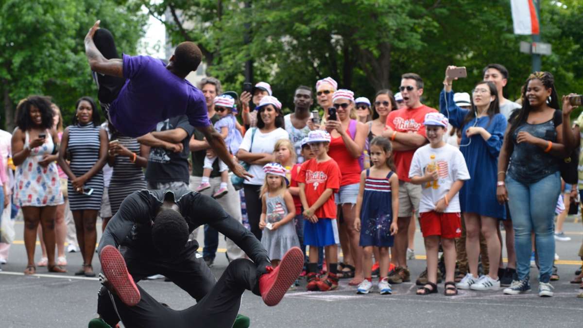 Najee Rose, with Inspired Visions United, entertains a crowd as he jumps over fellow performers on the Parkway.