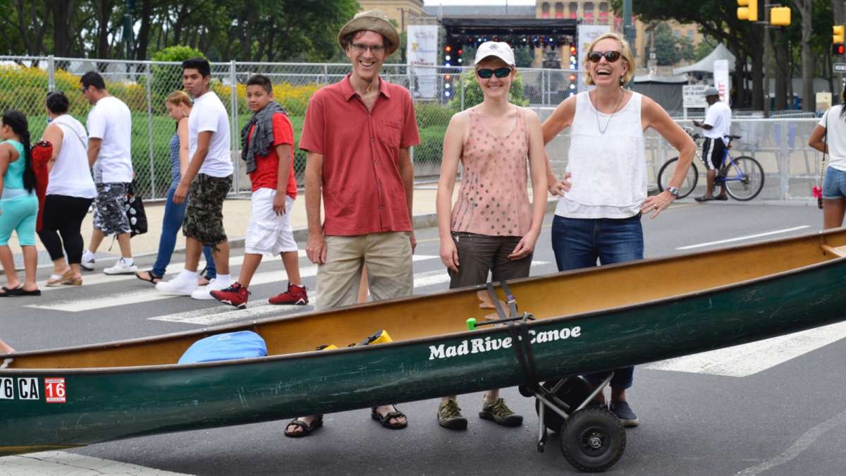 Paddlers Simon and Jean knight, with guest Susan Burrows, maneuver their canoe over the festival grounds heading to the Schuylkill River.