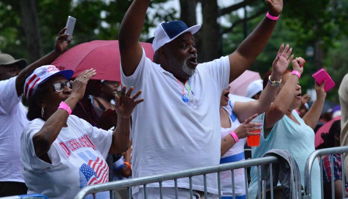 The crowd reacts with enthusiasm despite the rain.