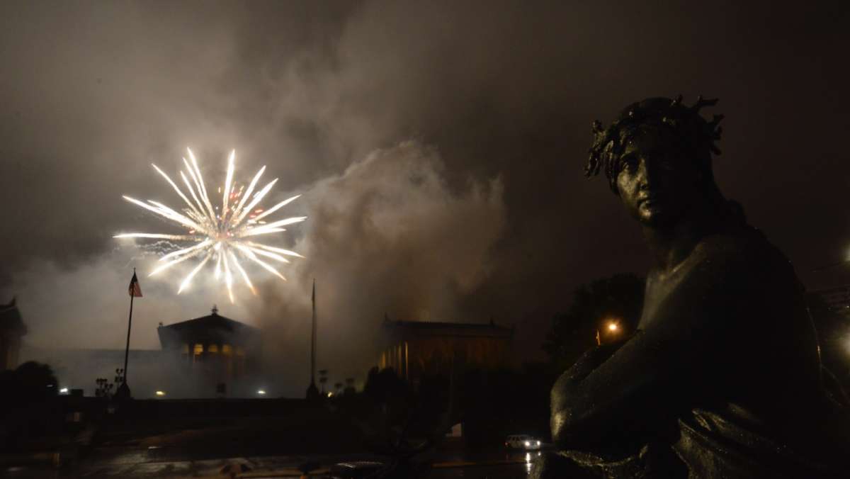 Rain and fog obscure the fireworks display at the art museum.