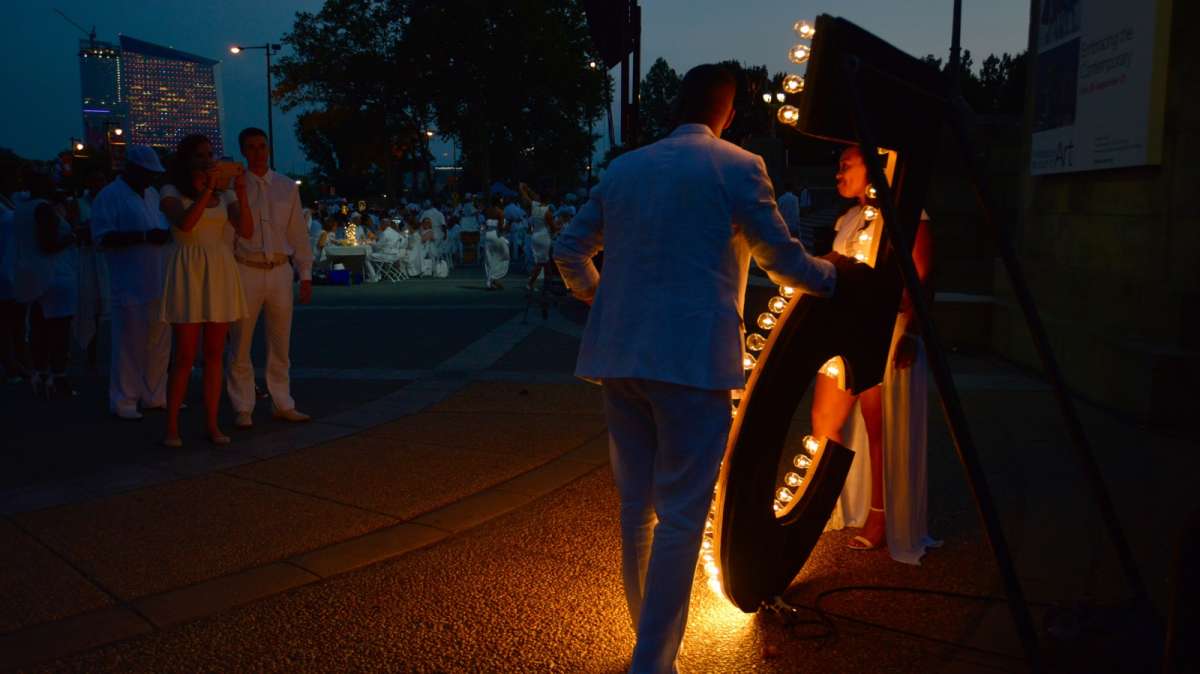 As night falls guests take the opportunity to pose for pictures with a large, illuminated number five.