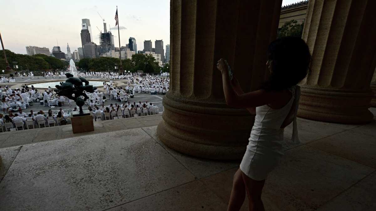 Courtney Yzzi makes a panoramic photo as she stands between the columns of the art museum.