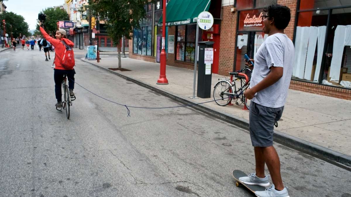 A skateboarder hitches a ride on South Street during Philly Free Streets day on Saturday.