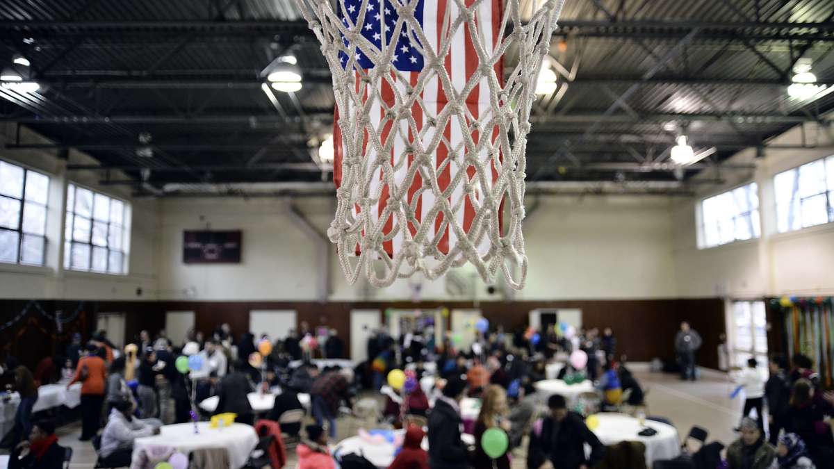 The hoops of the gym at the Old Pine Community Center are decorated with American flags as refugees take part in a Thanksgiving dinner on Sunday. (Bastiaan Slabbers for NewsWorks)