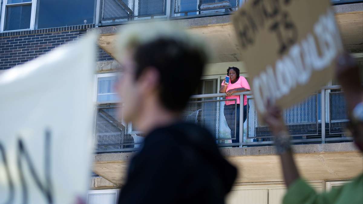 Tara Harvey-Turner looks down from the balcony as residents protest their eviction of Penn Wynn House.