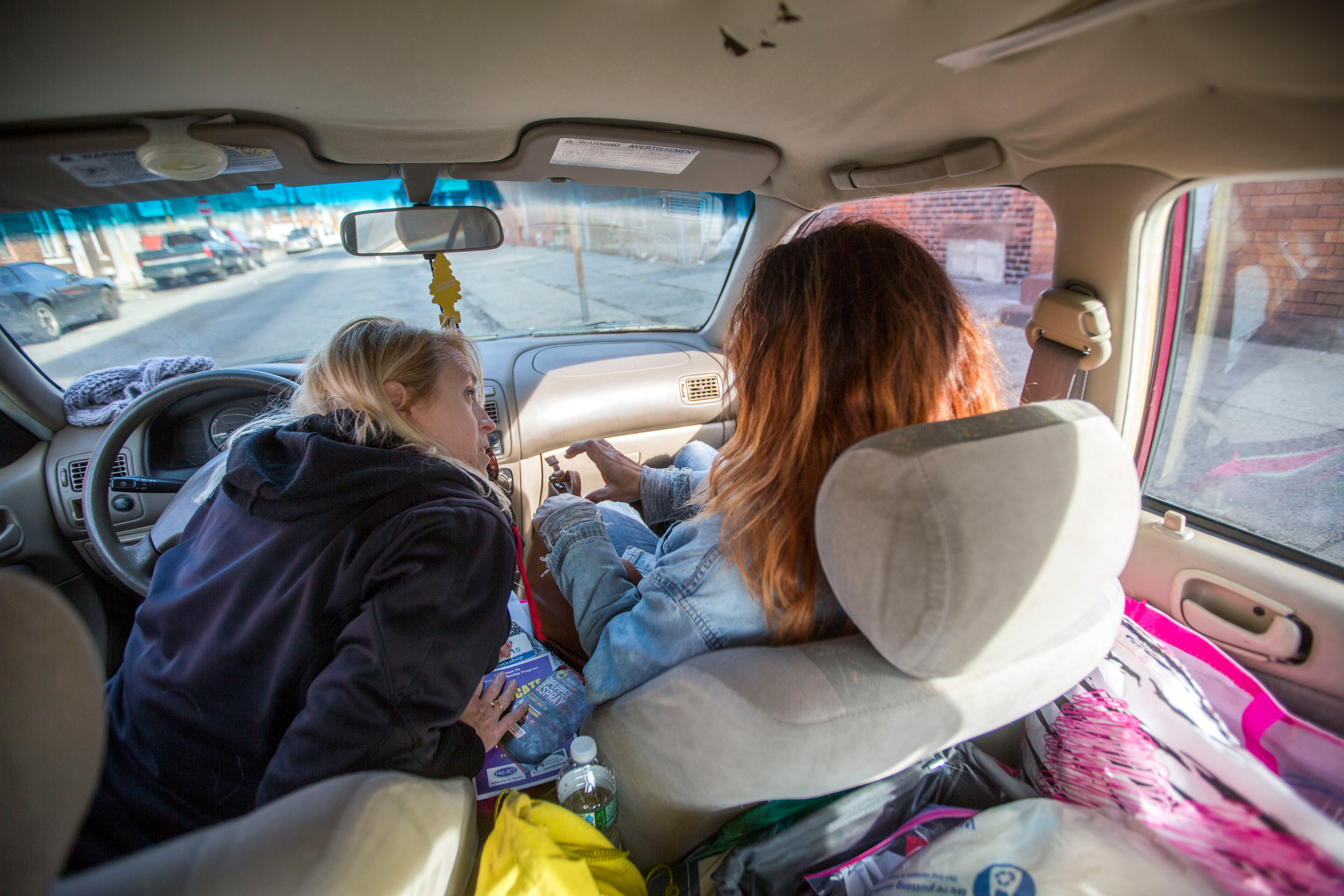 Carol Rostucher (left) and Barb Burns ride through the Kensington neighborhood of Philadelphia doing outreach to the homeless and those struggling with addiction. Rostucher started the non-profit Angels in Motion. (Jessica Kourkounis/For Keystone Crossroads)