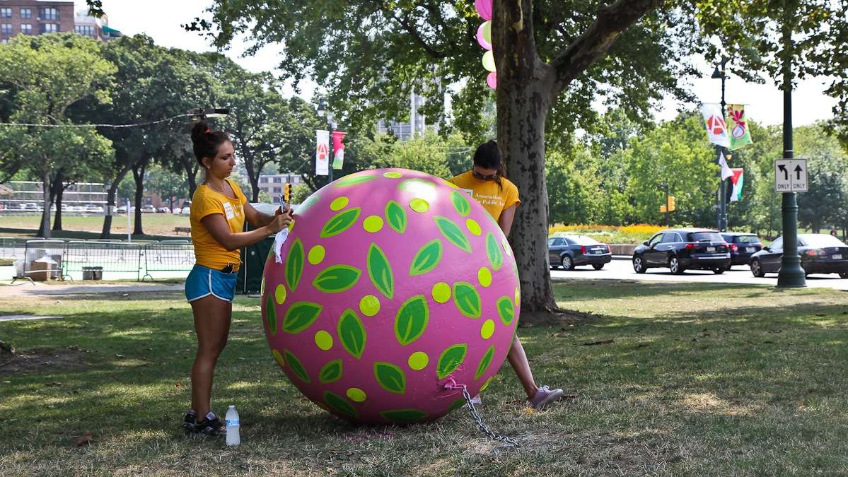 Kala Hagopian and Ali Williams touch up buoys that surround the Eakins Oval magic carpet. (Kimberly Paynter/WHYY)