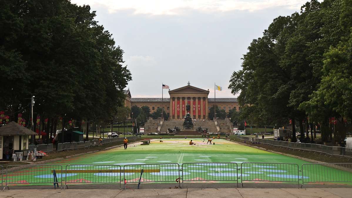 Painters work to turn Eakins Oval into a magic carpet Sunday evening. The official opening event is Wednesday July 16th. (Kimberly Paynter/WHYY)