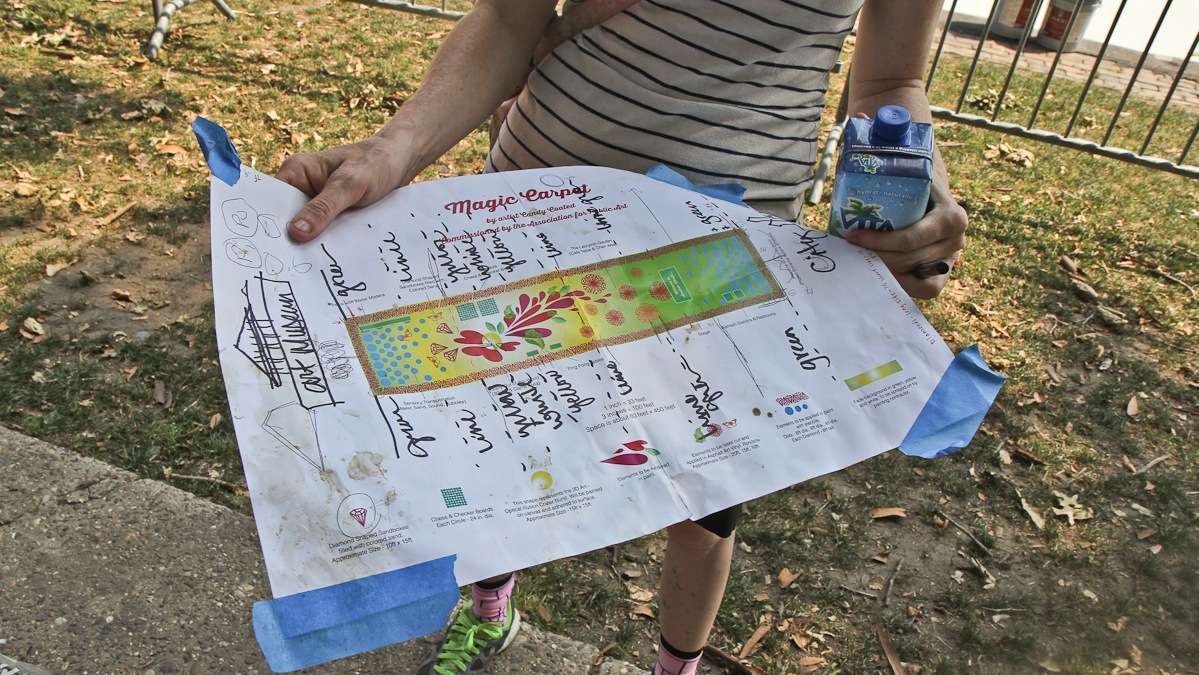 Artist Candy Coated holds the plans for turning Eakins Oval into a magic carpet. (Kimberly Paynter/WHYY)