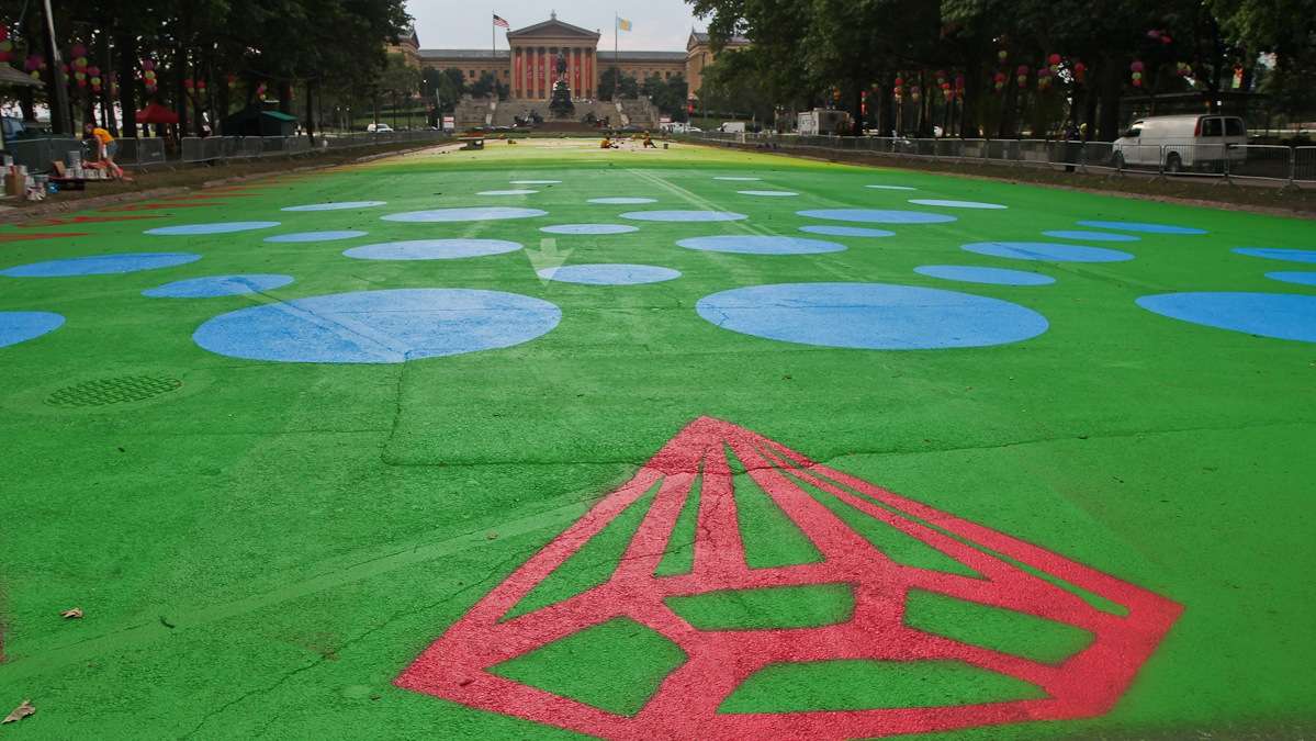 Painters work to turn Eakins Oval into a magic carpet Sunday evening. The official opening event is Wednesday July 16th. (Kimberly Paynter/WHYY)