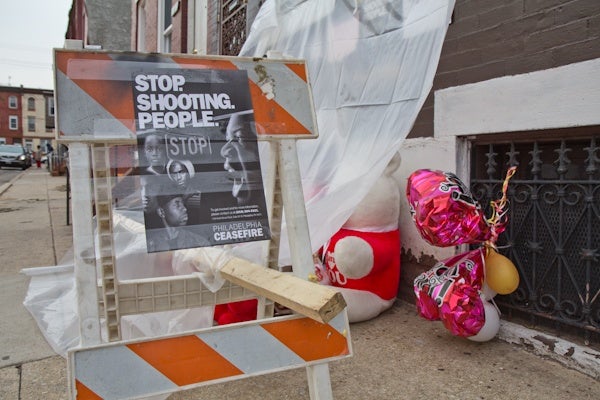 CeaseFire Philadelphia posts fliers at the site and memorial of a recent shooting in North Philadelphia. (Kimberly Paynter/For NewsWorks)
