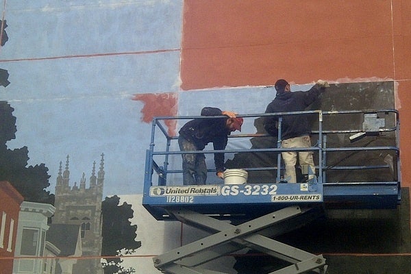 <p><p>Last week, artists took the wall and applied pre-painted panels to serve as a base for the mural. (Brian Hickey/WHYY)</p></p>
