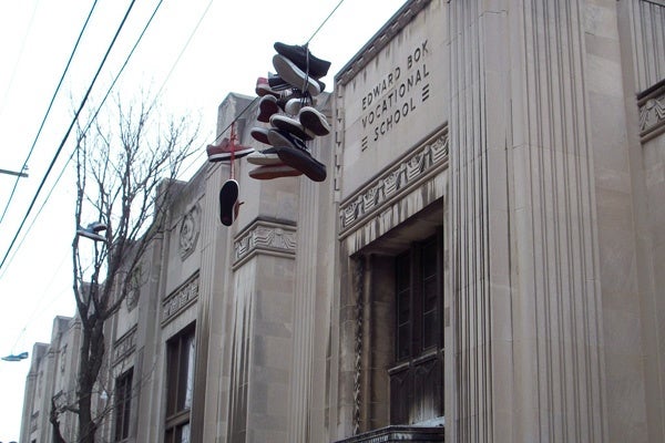 A familiar sight in South Philadelphia, shoes are flung up to hang from power lines in front of Edward Bok High School, at 9th and Mifflin streets. (Eric Walter/WHYY)