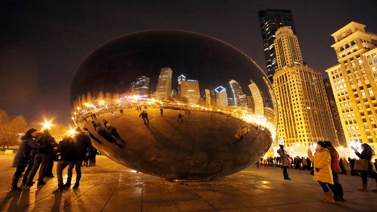  People enjoy the Cloud Gate sculpture, also known as ‘The Bean’ in Millennium Park in Chicago.  (AP Photo/Nam Y. Huh)  