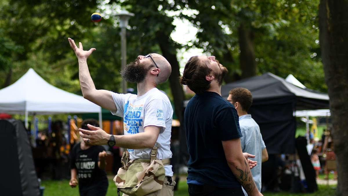 Christian Johnson, of East Mt Airy and Ken Haines, of Manayunk share some skills as they practice a juggling routine under the trees during the annual Clark Park Festival