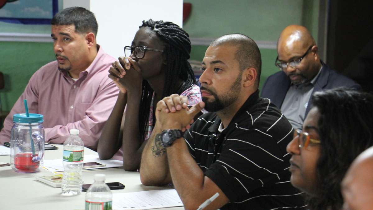 About 30 people attended a meeting in the basement of the Iglesia Del Bario church in Kensington to learn about the plan to clean up the heroin encampment on the Conrail tracks at Gurney Street. (Emma Lee/WHYY)