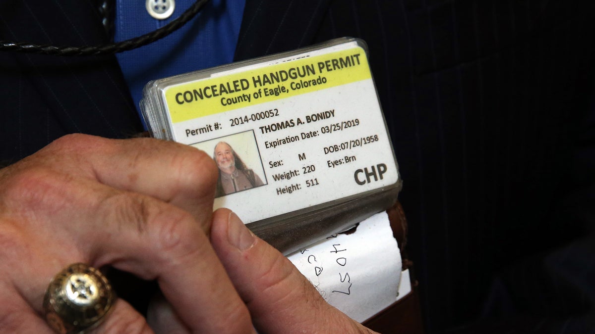  A Colorado man shows his concealed gun license. AP Photo/Brennan Linsley, file) 