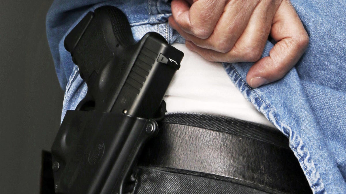 A man displays his concealed handgun in this 2013 file photo. (AP Photo/Al Behrman, File)                       
