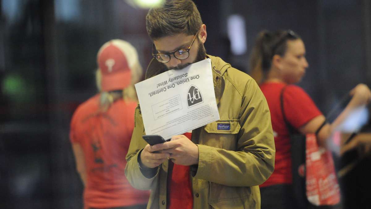 Teacher Joshua Kleiman checks his phone as he leaves the Liacouras Center after voting.